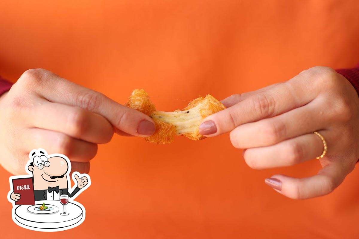 Coxinha sendo aberta com recheio de queijo